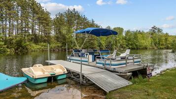 A dock with a covered boat, a small boat, and a 'NO DIVING' sign.