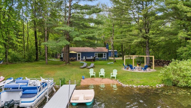 A lakeside cabin with a dock, outdoor seating, and a fire pit. - Lakefront: Hot Tub, Sauna, Firepit & Pontoon Fun (Wautoma)