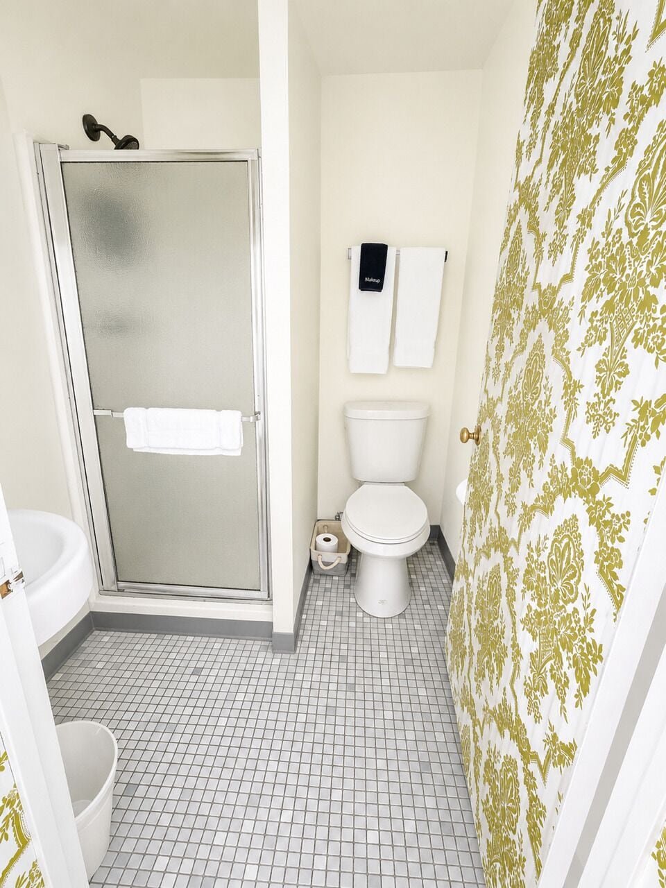 Une salle de bain avec douche, toilettes et lavabo.