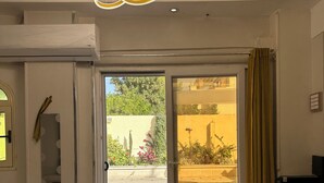 A spacious room with a large sliding glass door leading to an outdoor pool area, a modern chandelier, and a marble floor. - privet villa close to the beach (Hurghada)