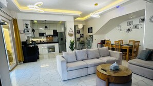 A modern living room with a sofa, a coffee table, and a dining area with chairs. - privet villa close to the beach (Hurghada)
