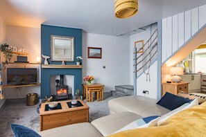 A cozy living room with a fireplace, a television, and a comfortable seating area. - Charming cottage in a great location in Dover, just 10 minutes walk from the beach (Dover)