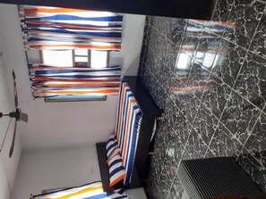 A room with a bed, striped curtains, a window, and a marble wall. - Impeccable 3-bed Apartment Located in Lagos (Lagos)