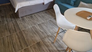 Ein Zimmer mit einem Bett, einer Couch, einem Tisch und einer Klimaanlage.