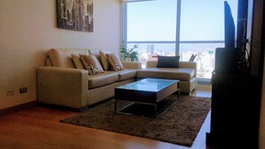 A living room with a sofa, a coffee table, and a TV. - Miraflores Upper Pardo Apartment 3bedroom/4baths (Miraflores)