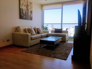 A living room with a sofa, a coffee table, and a TV. - Miraflores Upper Pardo Apartment 3bedroom/4baths (Miraflores)