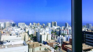 Eine Stadtansicht mit Blick auf das Meer und einem hohen Gebäude im Vordergrund.
