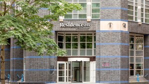 Un bâtiment en briques doté d’une grande entrée en verre et d’une enseigne indiquant « Residence Inn by Marriott ».