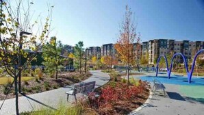Um parque com caminhos, bancos e equipamentos de playground.