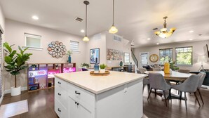 A spacious kitchen with a central island, pendant lighting, and a dining area with chairs and a table. - Exceptional Location & Vibes, New Décor, Artwork, & Furnishing, Community Pool, 8 Miles to Portland (Beaverton)
