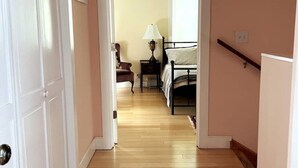 Une chambre à coucher avec un lit, une table de chevet, une lampe et une chaise.