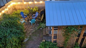 Un espace patio aménagé avec du mobilier d’extérieur et une clôture en bois.