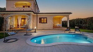A two-story house with a swimming pool, outdoor seating, and a covered patio area. - Villa Càrula: Private swimming pool near Lu Impostu (San Teodoro)