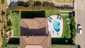 An aerial view of a residential property with a swimming pool, a covered patio, and a car parked on the street. - Villa Càrula: Private swimming pool near Lu Impostu (San Teodoro)