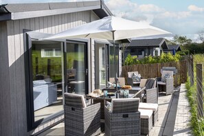 A patio area with outdoor furniture, a covered seating area, and a view of the surrounding landscape.