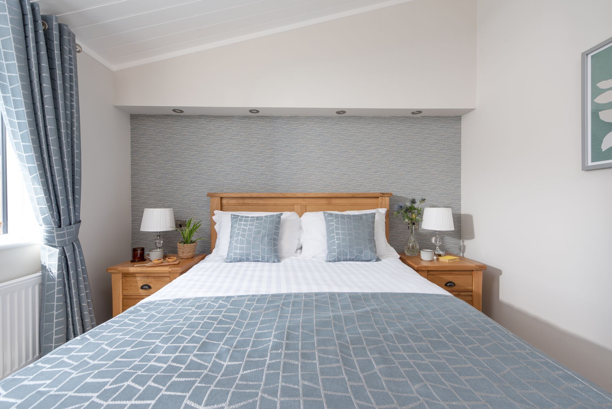 A neatly arranged bedroom with a bed, two bedside tables, and a headboard.