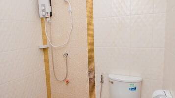 Un baño con ducha, inodoro y panel de control.