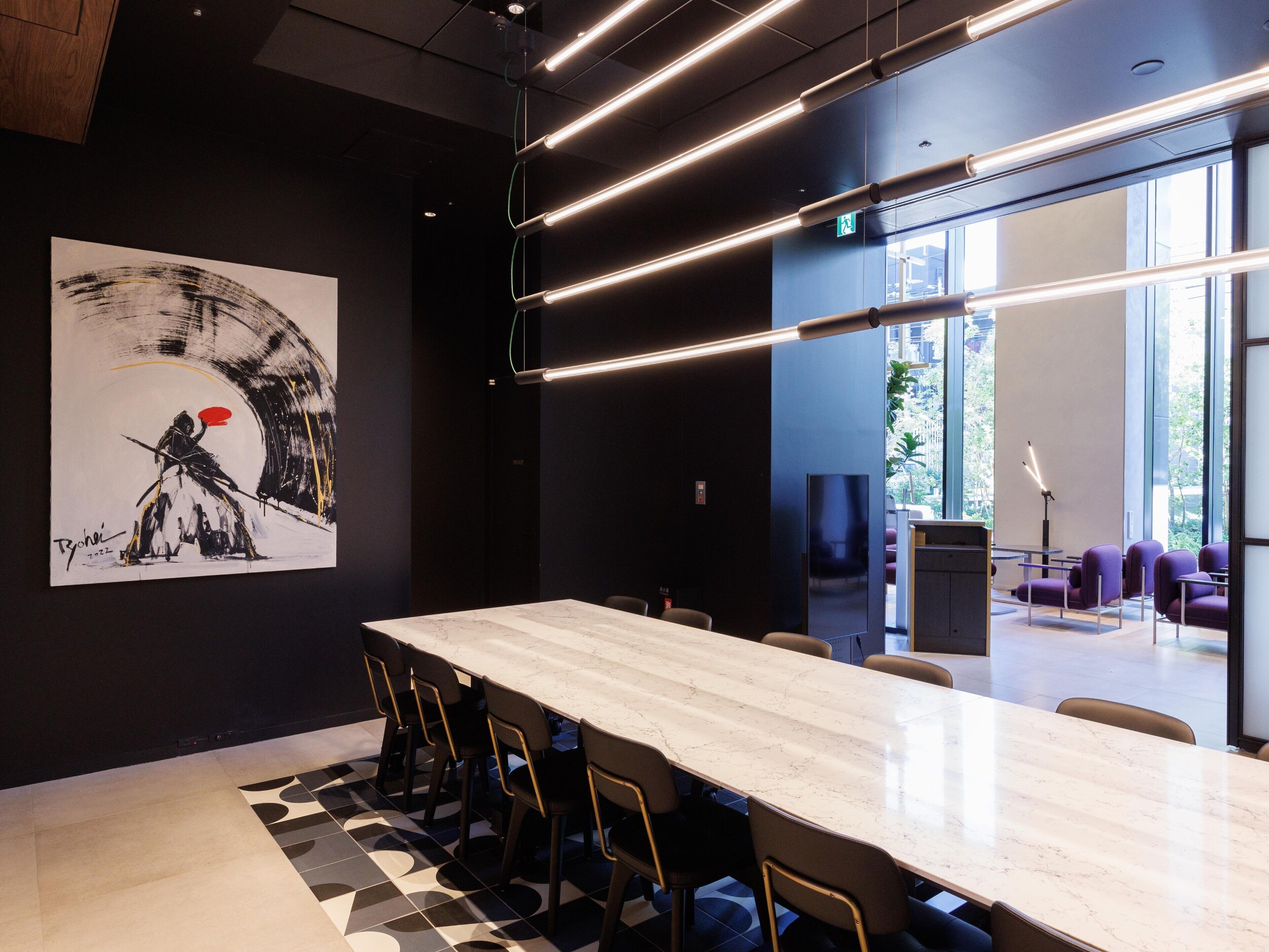 A modern conference room with a marble table, black and white patterned floor, and a large abstract painting on the wall.