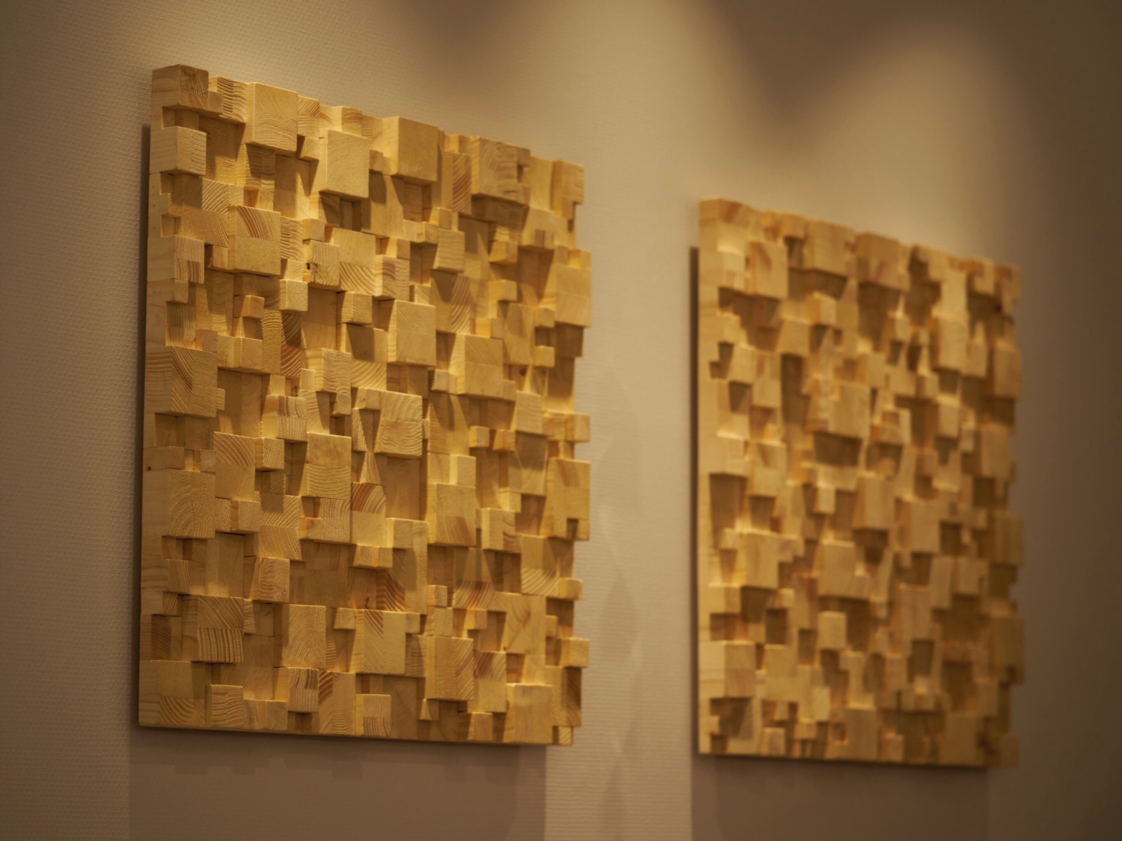 Two wooden wall art pieces with a textured, geometric pattern.