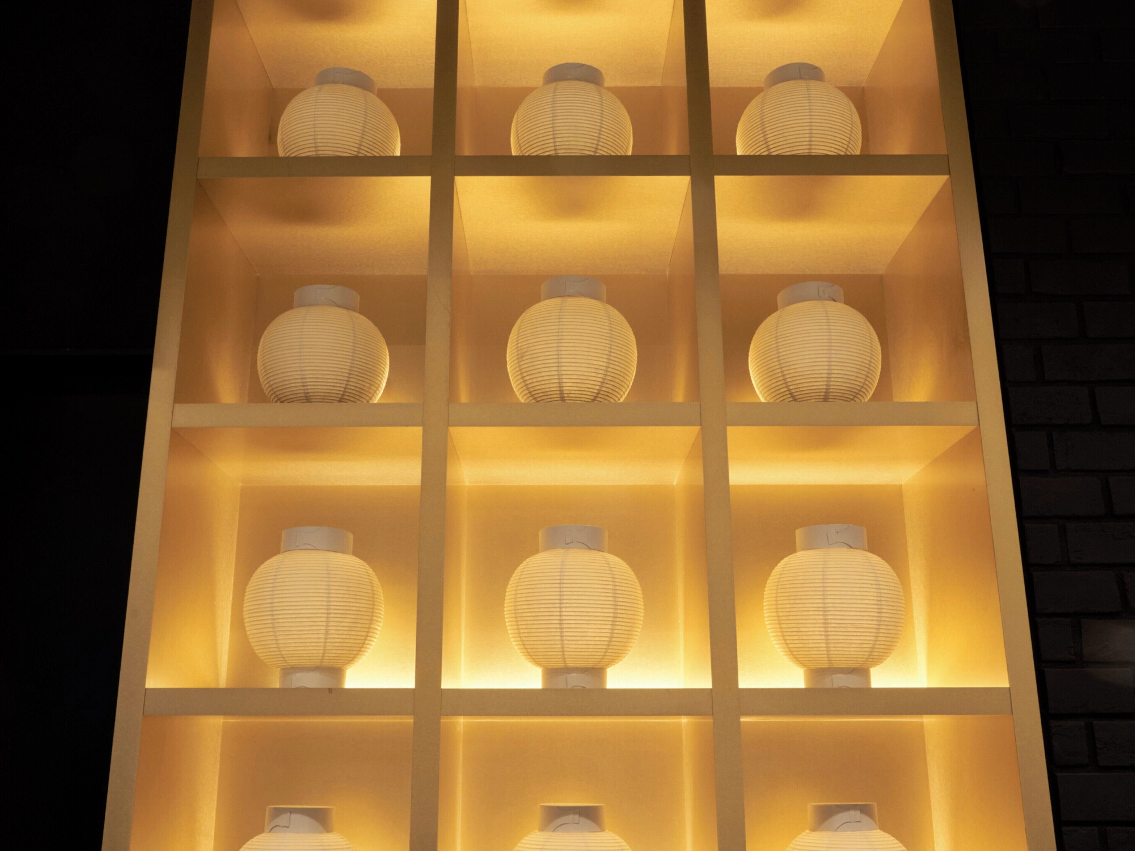A wall with multiple shelves, each holding a spherical object.