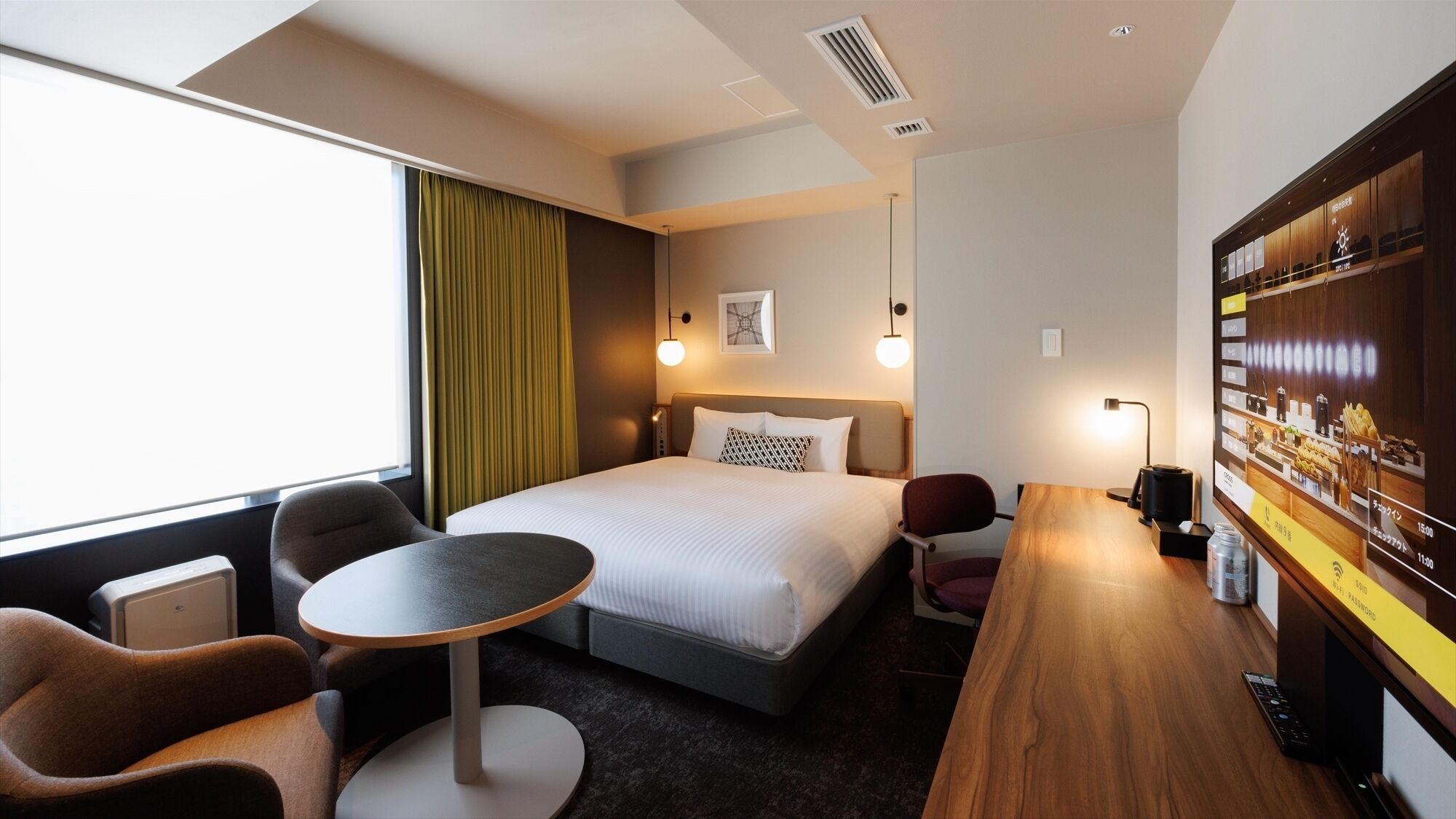 A hotel room with a bed, a desk, a chair, a small table, a TV, and a window with curtains.