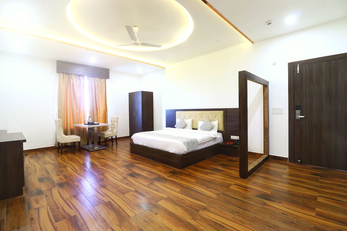 Quarto de hotel moderno com uma cama grande, uma escrivaninha e uma cadeira.