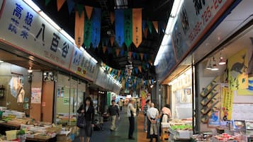 Un marché couvert animé où l’on trouve divers étals vendant des produits de la mer et d’autres marchandises.