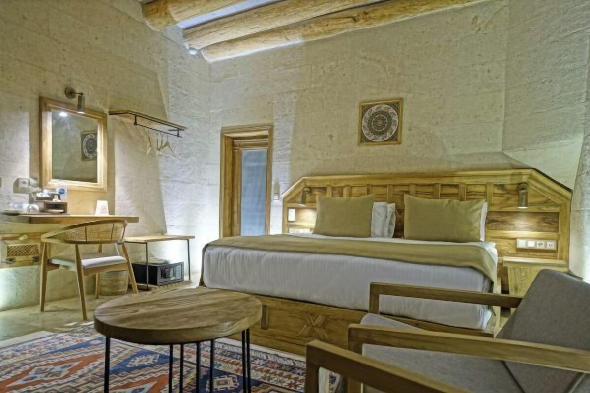 Un dormitorio con una cama, un escritorio, una silla y una mesita.