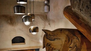 A wooden ceiling with hanging lights, a wooden horse head sculpture, and a wooden door with a decorative handle. - Kappadoks Cave Hotel (Nevsehir)