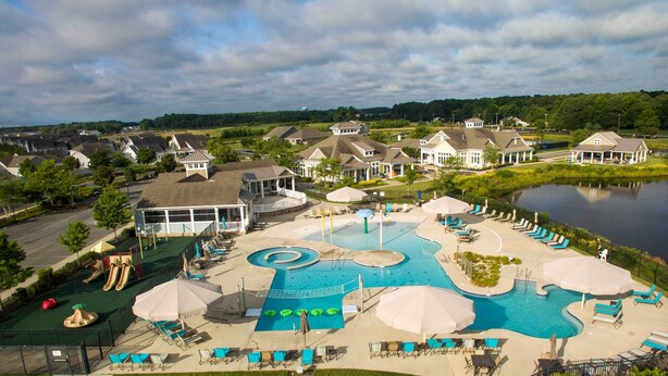 A resort with a large swimming pool, multiple lounge areas, and a scenic view of a lake. - Family-Friendly Home: 4 Mi to Bethany Beach! (Millville)