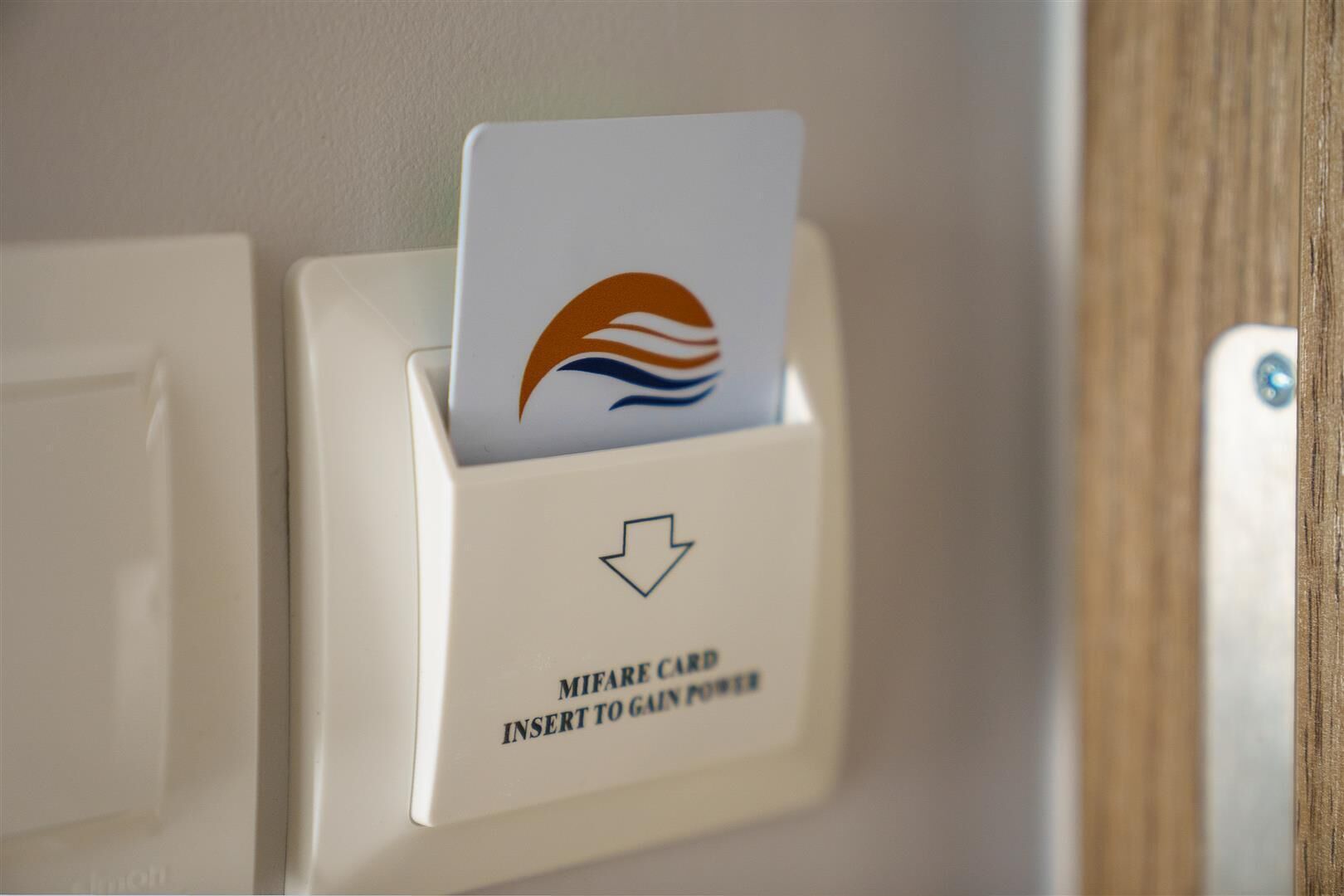 A card reader with a card inserted, labeled for MIFARE card insertion to gain power.