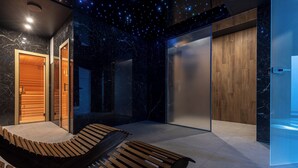 A modern spa room with a wooden bench, a massage table, and a ceiling with a starry design. - Belmar Park (Wladyslawowo)