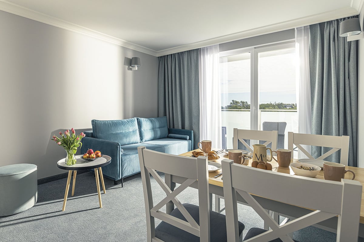 Een moderne hotelkamer met een zithoek, een bank en uitzicht op het landschap.