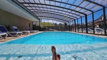 Una piscina al aire libre de temporada, sillones reclinables de piscina