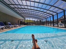 Una piscina al aire libre de temporada, sillones reclinables de piscina