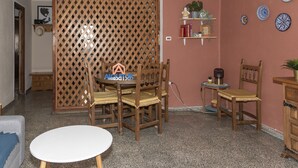 A room with a wooden table and chairs, a white round table, a wooden cabinet, and a decorative wooden partition. - SAINT GERMAIN, A-2º-4 (Cullera)