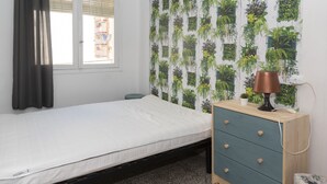 A bedroom with a bed, a dresser, a window with curtains, and a wall with a vertical garden. - SAINT GERMAIN, A-2º-4 (Cullera)