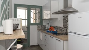 A compact kitchen with a green door, white cabinets, a stainless steel trash bin, and a patterned backsplash. - SAINT GERMAIN, A-2º-4 (Cullera)