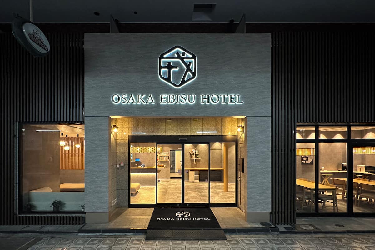 The exterior of Osaka Ebisu Hotel with a modern design, a reception area, and a visible dining space.