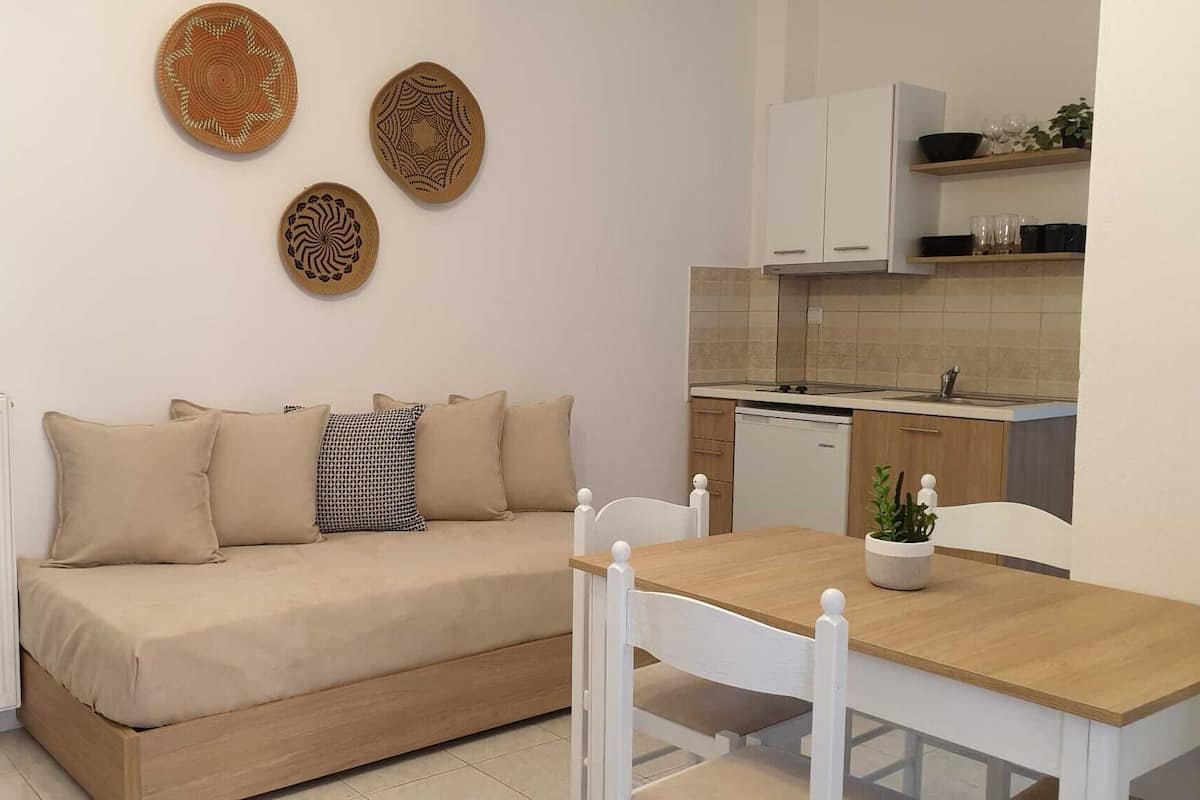 A compact living space with a sofa, a dining table, and a kitchen area.