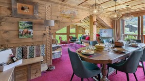 Un intérieur en bois comprenant un coin repas, un canapé et un téléviseur.