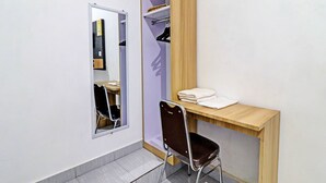 Un baño pequeño y moderno con un espejo, un mueble de tocador de madera, una silla y un estante con toallas.