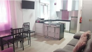 A modern kitchen with a central island, a dining area with a table and chairs, and a living area with a sofa. - Slaughterhouse Madrid 1 (Madrid)
