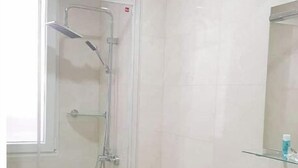 A modern bathroom with a glass shower enclosure, a white toilet, and a vanity with a mirror. - Slaughterhouse Madrid 1 (Madrid)