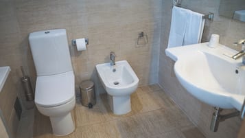 Un baño moderno con inodoro, bidé y lavamanos.