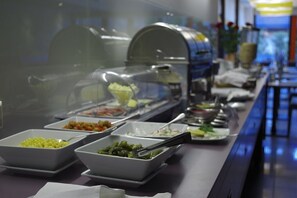 A buffet with various food options, including salads and vegetables, in a well-lit indoor setting. - Amber Sea Hotel (Jurmala)
