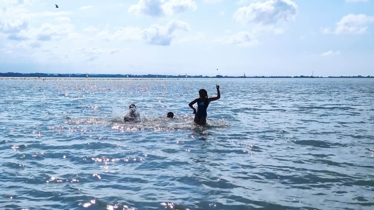 A body of water with people swimming and splashing.