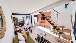 Een modern interieur met een trap, een eethoek en een woongedeelte.