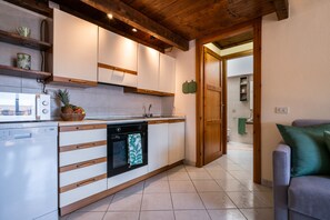 Une cuisine moderne avec des meubles en bois, un lave-vaisselle et un sol carrelé.