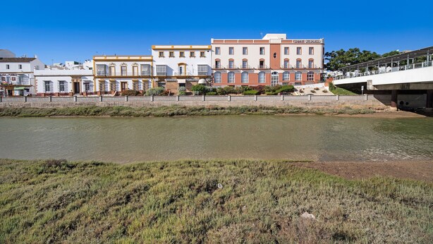 A hotel with a flat roof and a large window on the second floor. - Pet-Friendly Piso Arquillo del Reloj Apartment with Wi-Fi (Chiclana de la frontera)